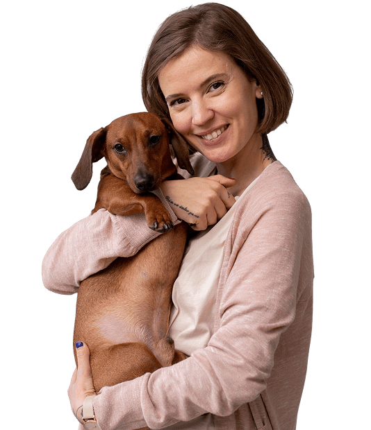 Mujer sonriente cargando perro salchicha concepto soporte emocional