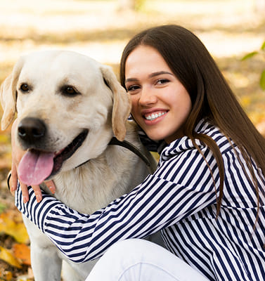 Mujer sonriente con perro labrador vinculo persona animal