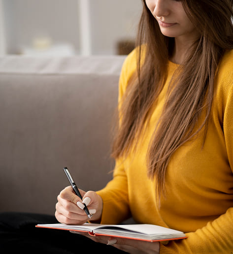 Mujer sueter amarillo escribiendo cuaderno investigación salud mental